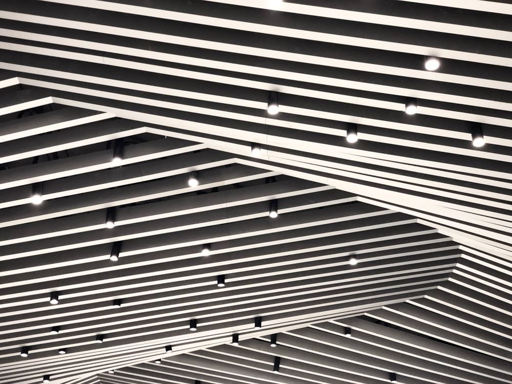 Metal Baffle & Linear Ceiling design by Soulnest Aura