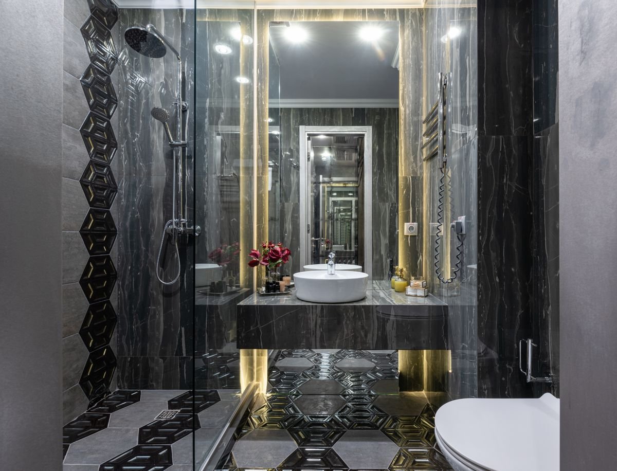 Black and Gold Hexagon-Tiled Bathroom with Glass Shower Enclosure