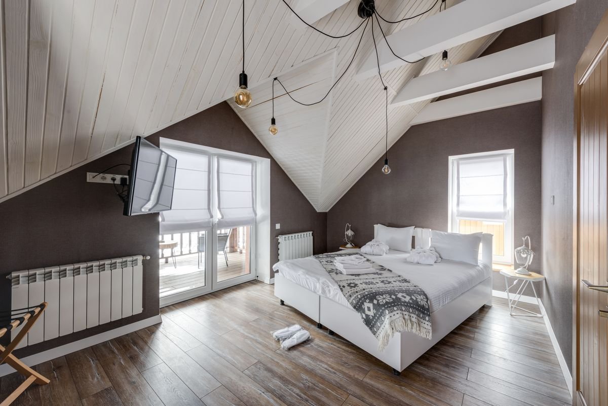 Vaulted Wood-Beam Guest Bedroom with Exposed Pendant Lighting