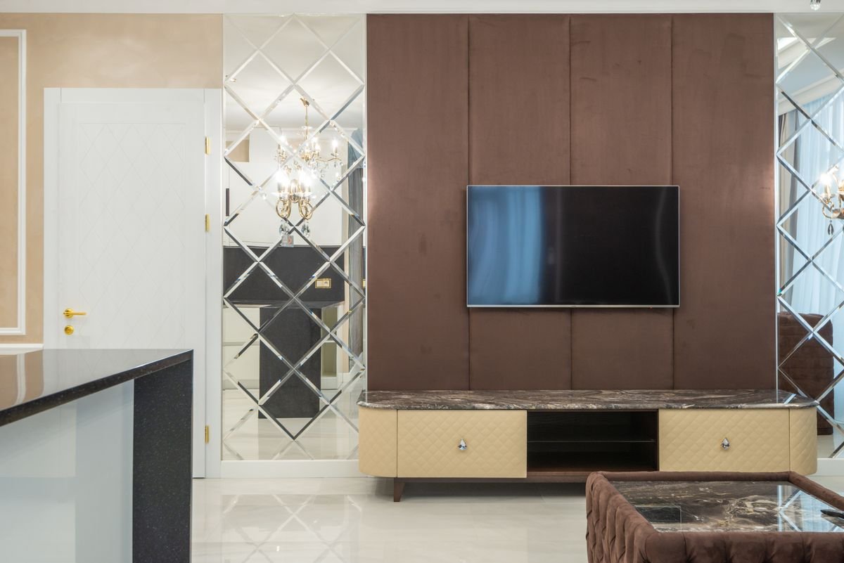 Upholstered TV Wall with Mirror Panels and Marble Console