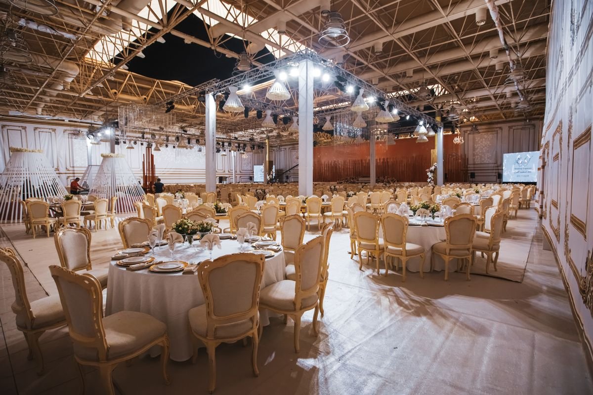 Spacious Event Hall with Gold Chiavari Chairs and Round Tables