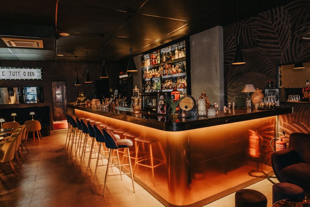 Glamorous Bar with Orange Backlit Counter and Bottle Wall