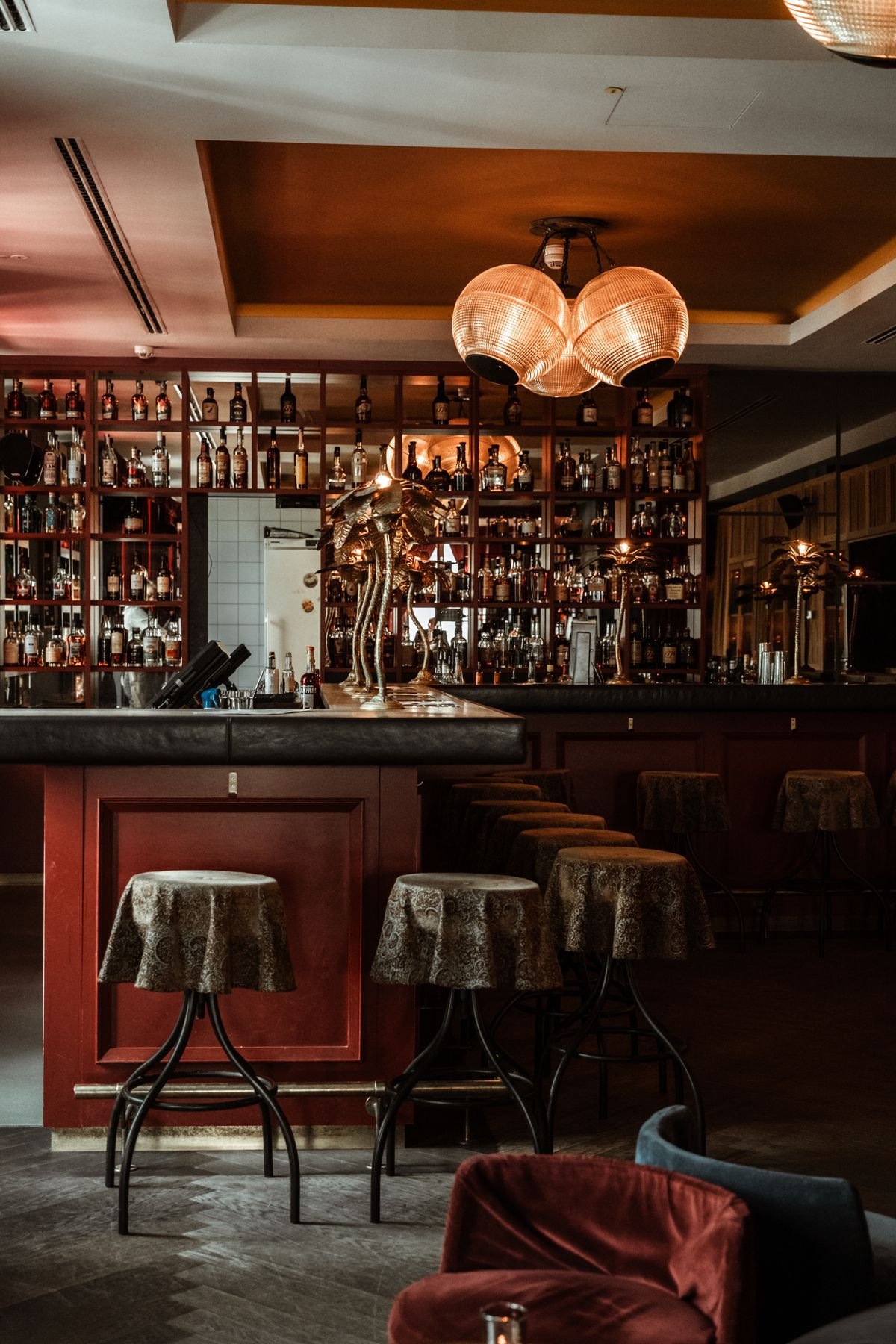 Vintage Bar with Brass Sculptures and Bottle Display Wall