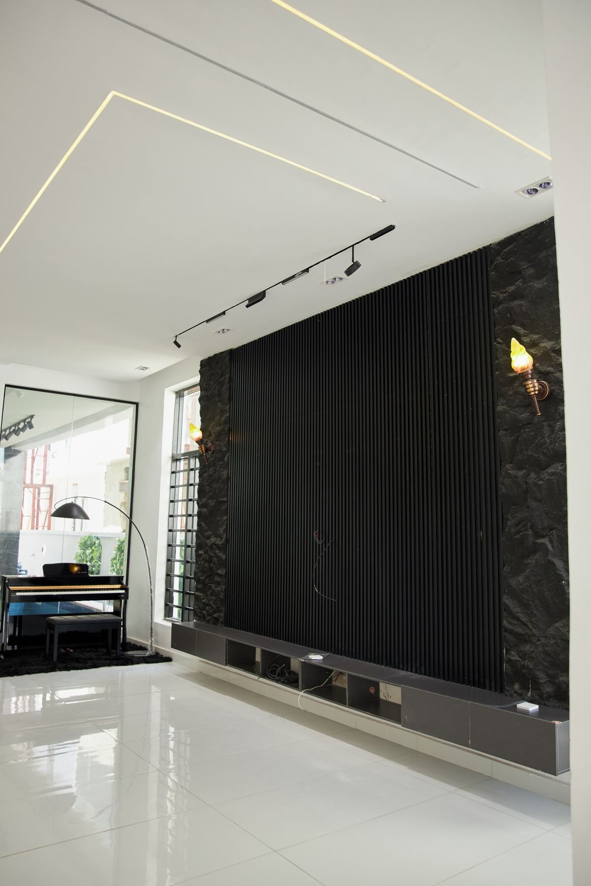 Modern living room with fluted black TV wall and linear cove lighting